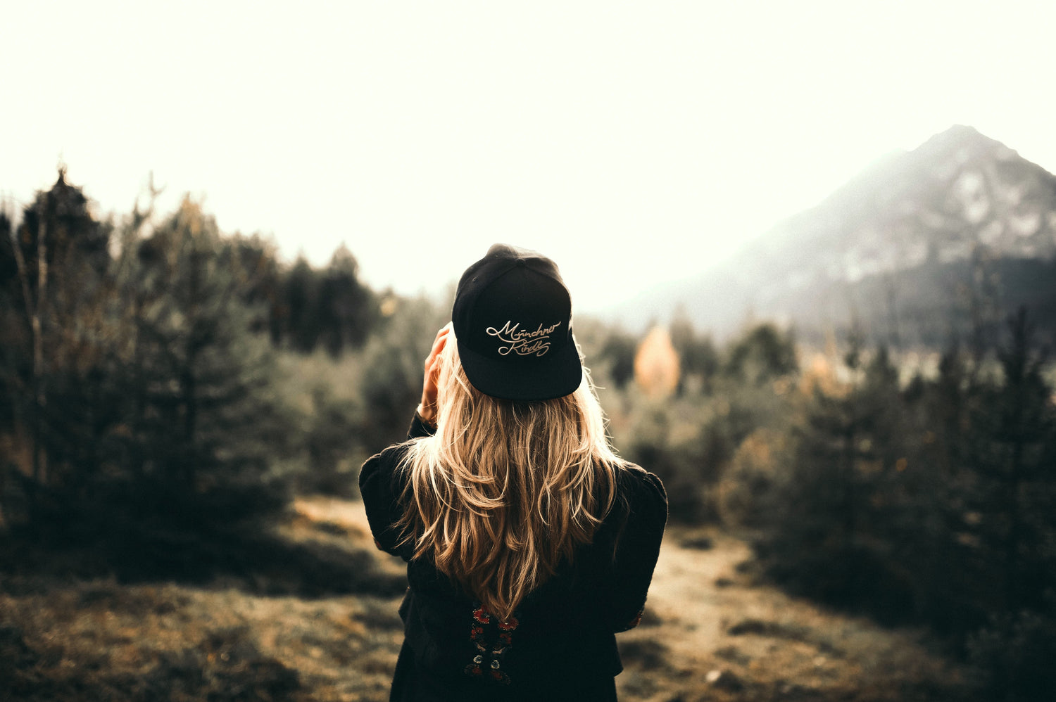 Woman in the mountains wearing a hat backwards